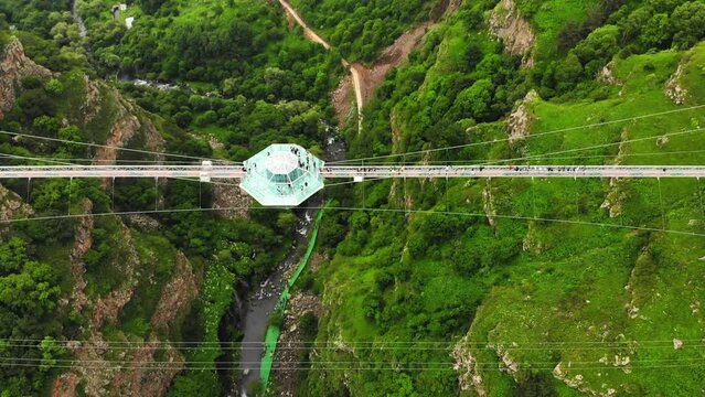 Dashbashi, Georgia - 19th june, 2022: Aerial circle over Diamond cafe on glass bridge over scenic dashbashi valley in Georgia countryside. Famous modern bridge over valley