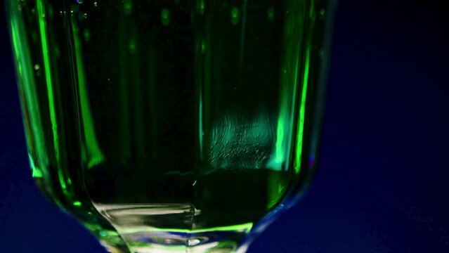 Close-up of green drink in glass. Stock clip. Bright green drink with alcohol in night bar. Alcoholic beverages in bars and clubs