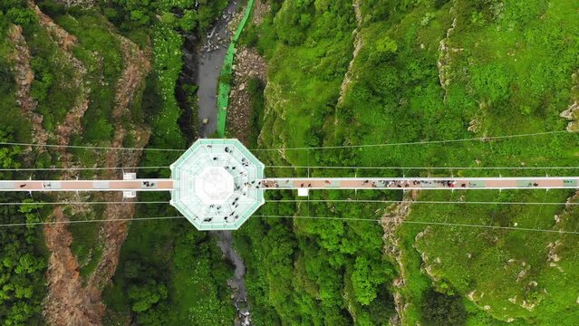 Dashbashi, Georgia - 19th june, 2022: Aerial panning view Diamond shape platform on glass bridge over scenic dashbashi valley in Georgia countryside. Famous modern bridge over valley