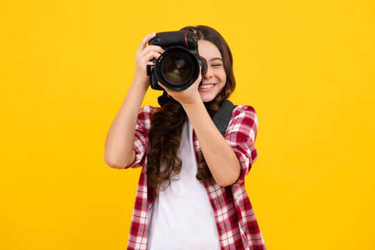 Teenager lifestyle, teen hipster hold professional camera. Girl with photo camera photographing, isolated on studio background. Happy teenager, positive and smiling emotions of teen girl.