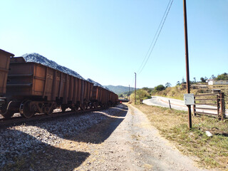 Fototapeta na wymiar Landscape showing train cars loaded with ore with side road at Itabira Minas Gerais Brazil