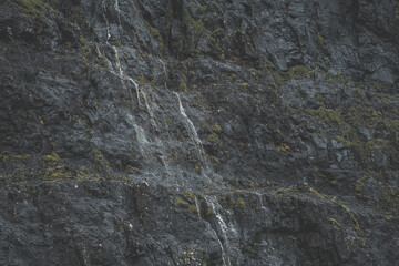 Small waterfalls in large rock face