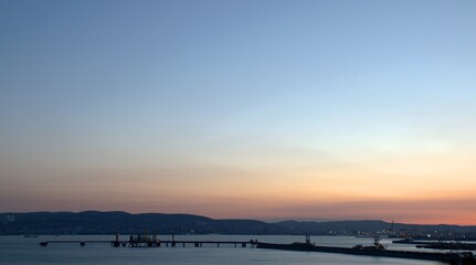 Evening city on the seacoast. Pink sunset. Clear blue sky. Black Sea. Novorossiysk. Krasnodar...
