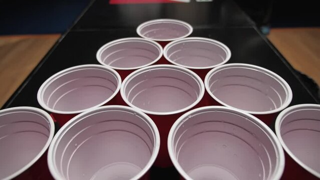 close up red plastic cups for beer pong play set up on dark background