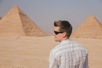 a tourist man looks at the Egyptian pyramids