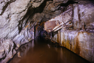 Dark flooded abandoned mine tunnel