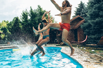 Fototapeta A young group of friends jumping into the swimming pool.Having fun and refreshing on a hot summer day.	
	
 obraz