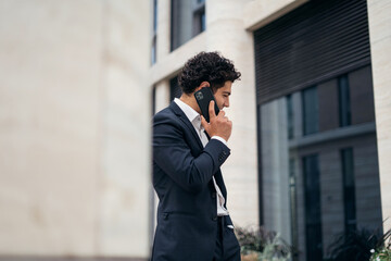 The businessman uses the phone, answers the client