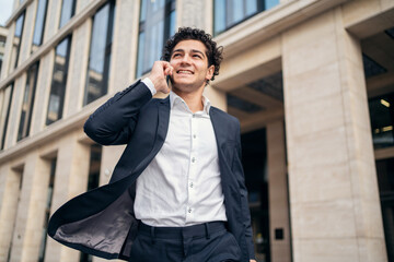 Fototapeta premium The male manager uses the phone, answers the client