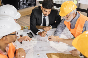 Qualified architects, engineers and designers having business meeting at office. Multicultural...