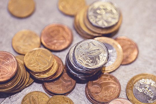 Real - A moeda brasileira. Pilhas de moedas do Real Brasileiro sobre uma mesa em fotografia macro. Conceitos de economia brasileira e finanças.	