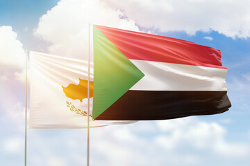 Sunny blue sky and flags of sudan and cyprus