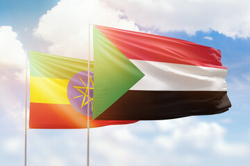 Sunny blue sky and flags of sudan and ethiopia