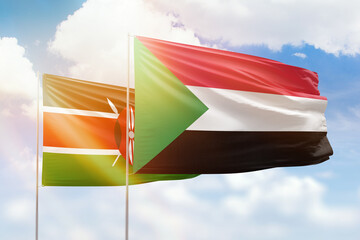 Sunny blue sky and flags of sudan and kenya
