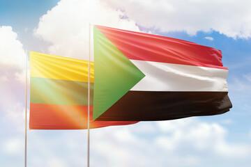 Sunny blue sky and flags of sudan and lithuania