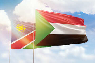 Sunny blue sky and flags of sudan and namibia