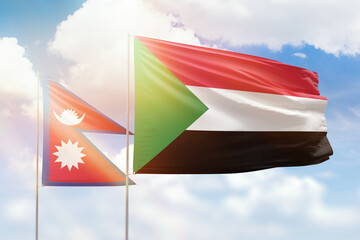 Sunny blue sky and flags of sudan and nepal