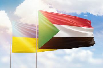 Sunny blue sky and flags of sudan and ukraine