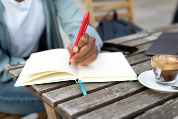 Student studying, holding pen taking notes in diary, selective focus. Close up of business woman...
