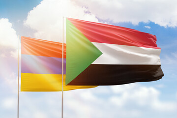 Sunny blue sky and flags of sudan and armenia