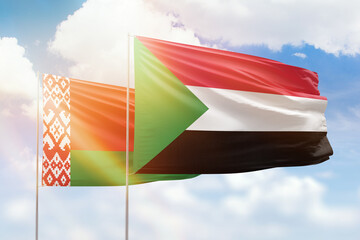 Sunny blue sky and flags of sudan and belarus