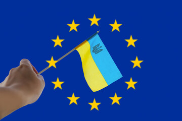 Defocus European union and Ukraine. Large national symbol fluttering. Support and help Ukraine, Independence Constitution Day, National holiday. Hand holding flag. Freedom. Out of focus