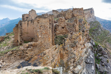 Old stone houses in Goor village, Dagestan, Russia. Ancient houses on ledges of rocks. Ruins of the abandoned village. Panoramic view of the ancient Goor settlement among the mountains