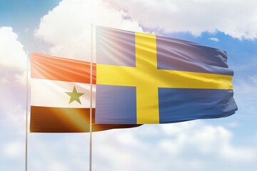 Sunny blue sky and flags of sweden and syria