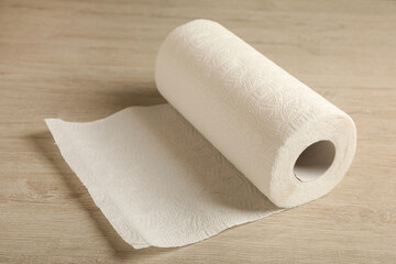Roll of paper towels on wooden table, closeup