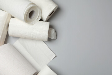 Many rolls of paper towels on grey background, flat lay. Space for text