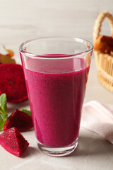 Delicious pitahaya smoothie and fresh fruits on light grey table