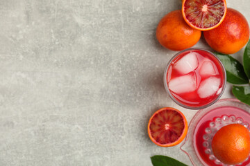 Naklejka na ściany i meble Tasty sicilian orange juice with ice cubes and fruits on light grey table, flat lay. Space for text