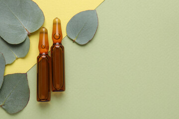 Pharmaceutical ampoules with medication and eucalyptus leaves on color background, flat lay. Space...