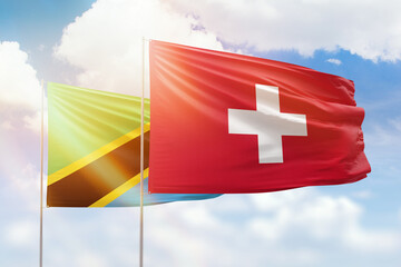 Sunny blue sky and flags of switzerland and tanzania