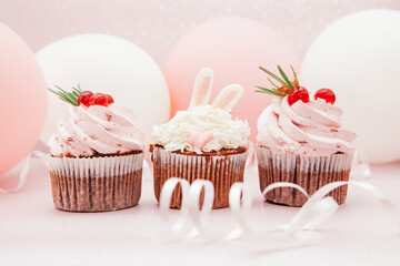 Sweets with pink cupcakes with bunny and air balloons, card with beautiful dessert	