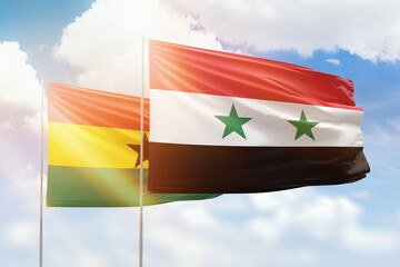 Sunny blue sky and flags of syria and ghana