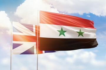 Sunny blue sky and flags of syria and great britain