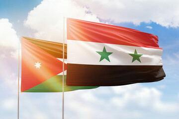 Sunny blue sky and flags of syria and jordan