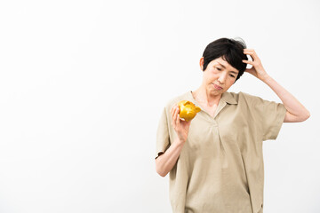 ブタの拠金箱を持って悩むミドル女性