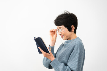 老眼鏡で読書をするミドル女性