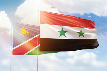 Sunny blue sky and flags of syria and namibia