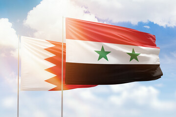 Sunny blue sky and flags of syria and bahrain