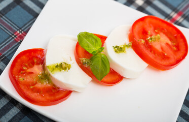 Plate of low calorie salad with slices of cheese and tomatoes