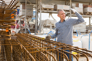 Construction shop worker prepares metal rebar for loading onto a truck