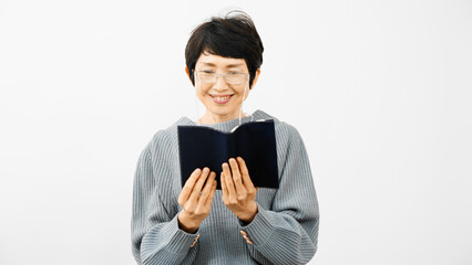 老眼鏡で読書をするミドル女性