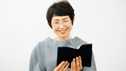 老眼鏡で読書をするミドル女性