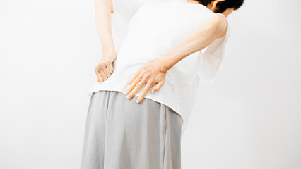 健康イメージ　腰をさするミドル女性 - obrazy, fototapety, plakaty