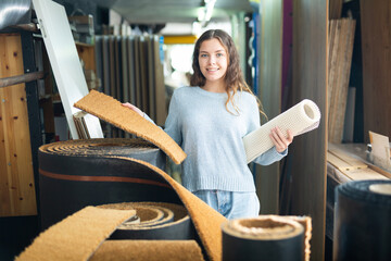 Woman consumer choosing carpet in a hardware store