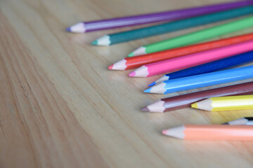Colored pencils on a wooden background.