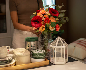 A person is arranging a beautiful flower vase in the dining room.